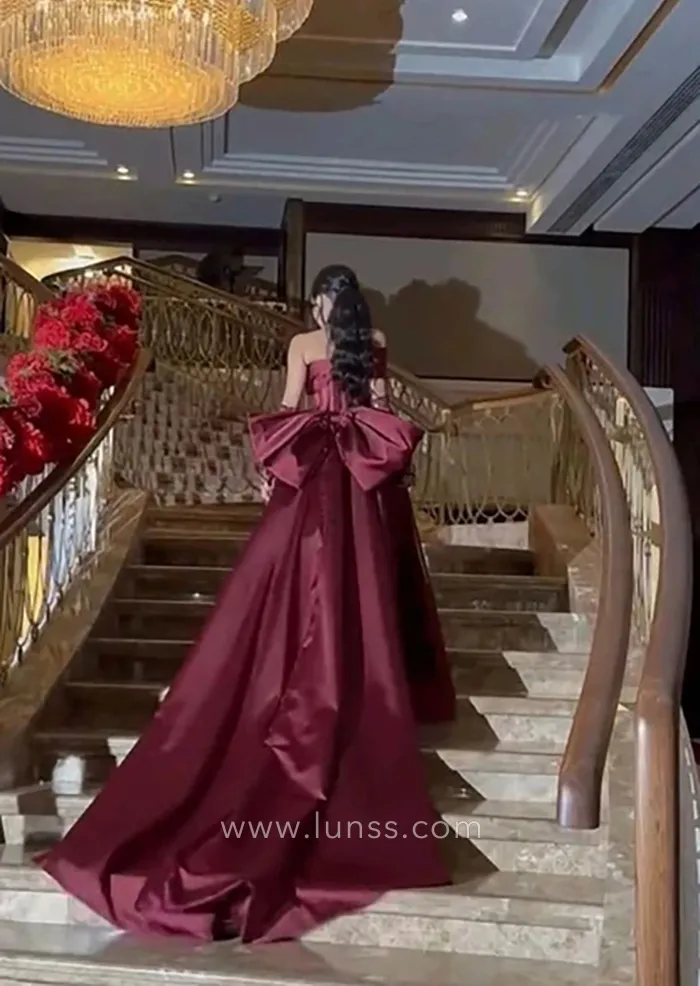 burgundy satin long train prom dress with an oversized bow