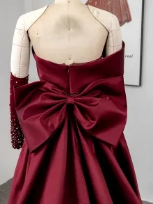 burgundy satin prom dress with a bow