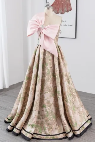 gold green floral prom gown with an oversized pink bow